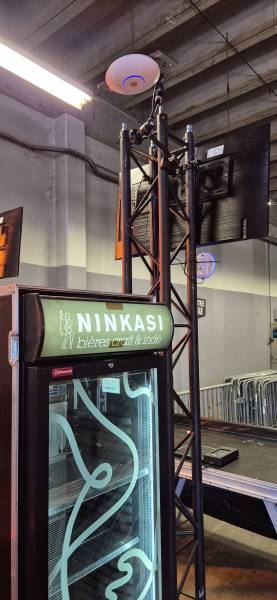 Connectivité chirurgicale : placée stratégiquement au-dessus du bar, cette borne Wi-Fi 6 gère la remontée des données des lecteurs de consigne et des terminaux de paiement. Une bulle de connexion dédiée pour éviter toute latence, même en pic d'affluence.